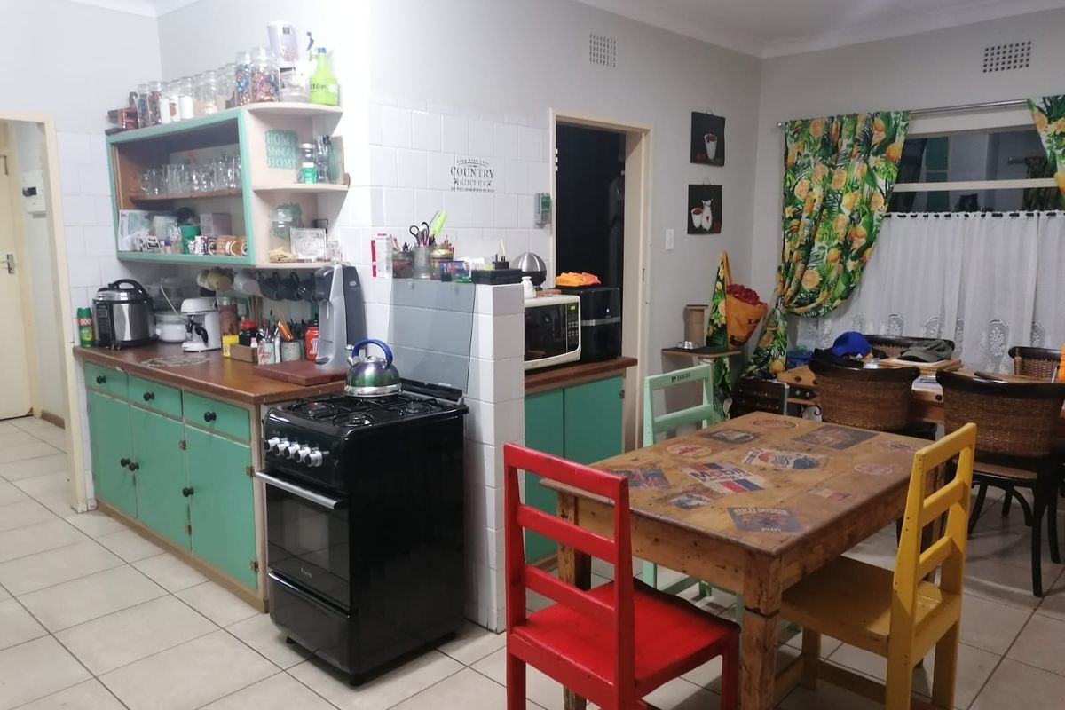 A functional kitchen featuring built-in cabinetry, a gas stove, and tiled flooring, offering a practical layout with potential for modern updates.