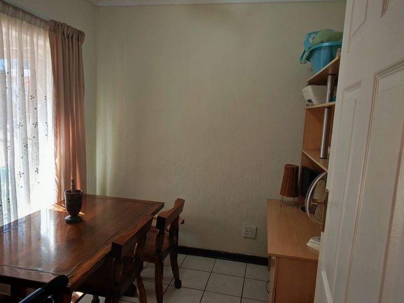 A dining area featuring tiled flooring and a large sliding glass door that provides natural light.