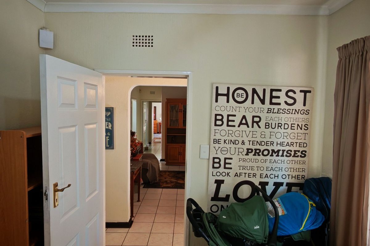 A view from a living area looking through an archway into an adjacent room, featuring tiled flooring and neutral wall finishes.
