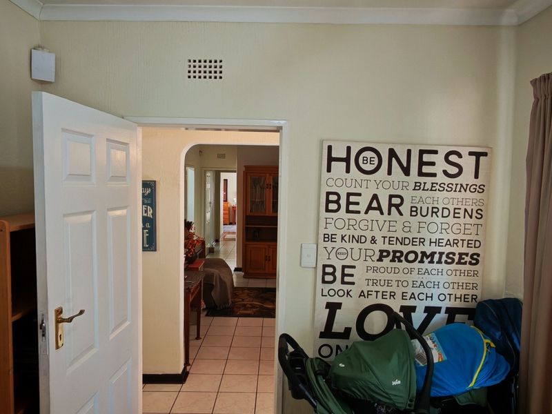 A view from a living area looking through an archway into an adjacent room, featuring tiled flooring and neutral wall finishes.