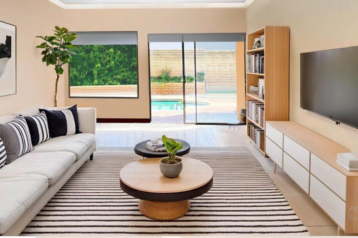 Bright living room featuring large sliding glass doors that open to a pool area, complemented by neutral tiled flooring and modern recessed lighting.