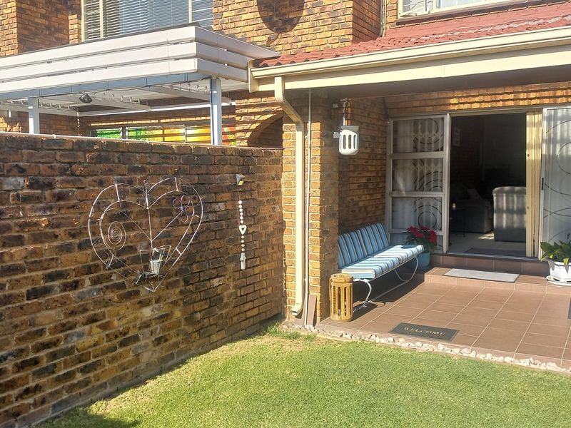 A private rear patio area featuring a tiled floor, covered roof, and direct access to the interior through a sliding glass door.