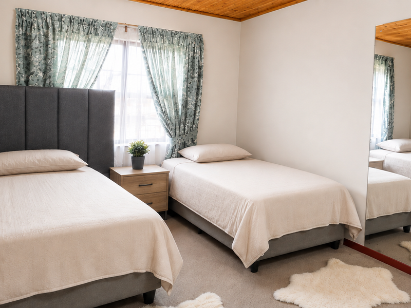 A bedroom featuring a timber ceiling and a large built-in mirror, providing a functional space with neutral finishes.