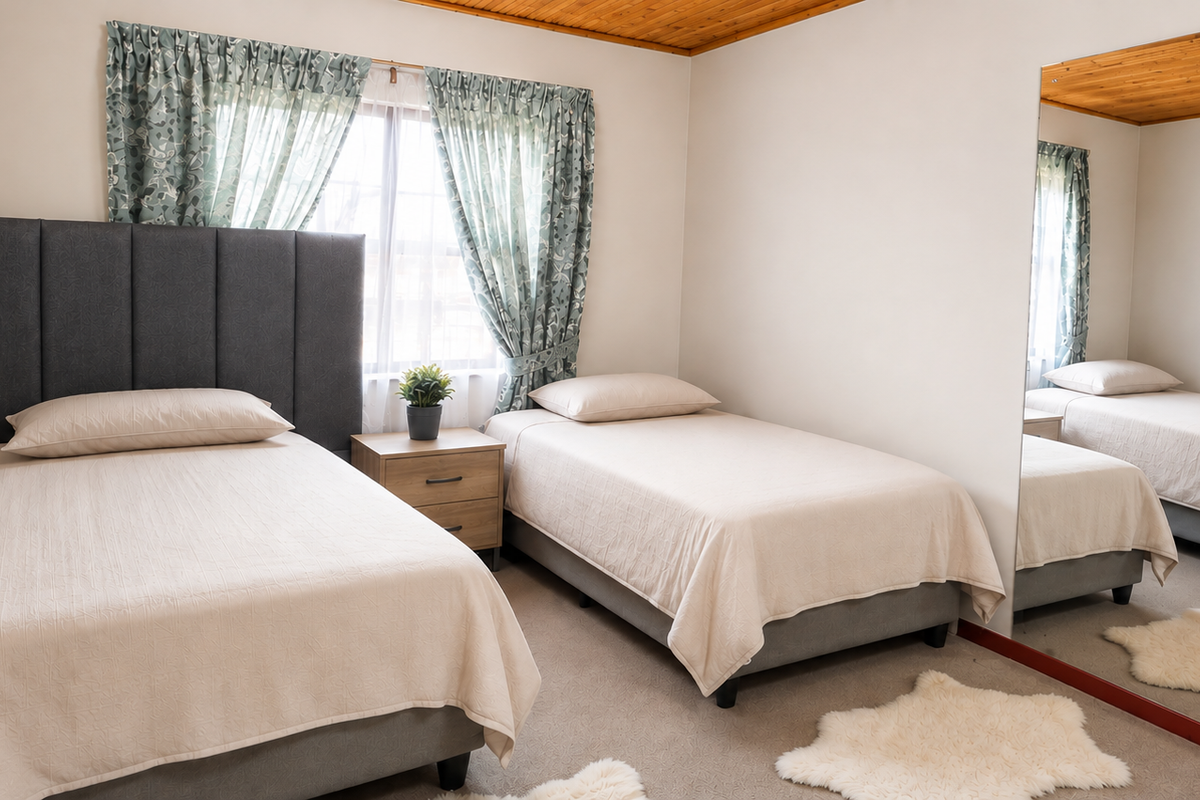 A bedroom featuring a timber ceiling and a large built-in mirror, providing a functional space with neutral finishes.