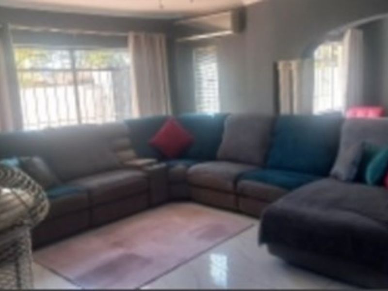 A living room featuring tiled flooring, an archway, and a wall-mounted air conditioning unit.