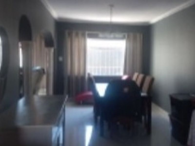 A dining room area featuring tiled flooring and decorative coving, viewed from an adjacent space.