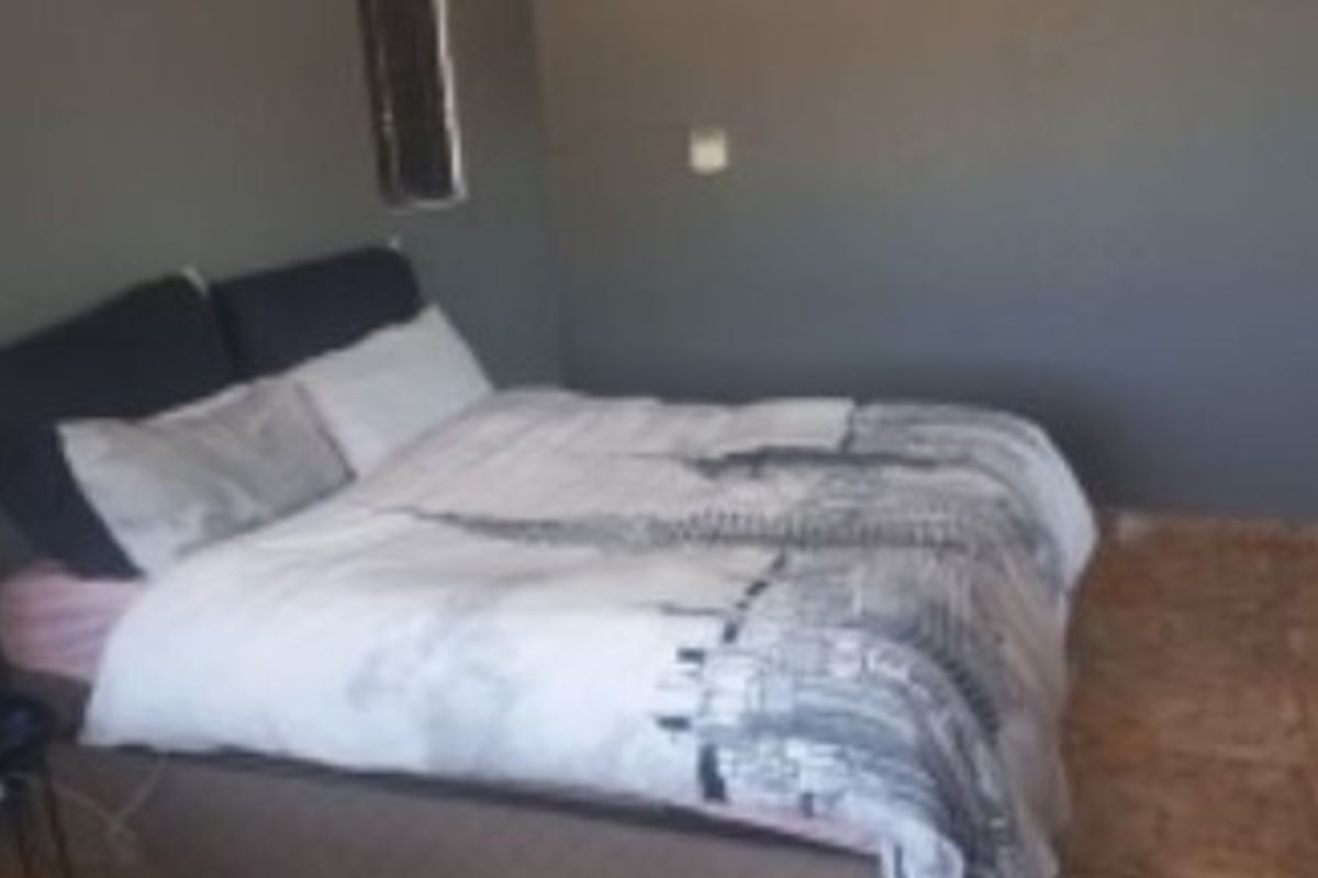 A bedroom featuring tiled flooring and dark-toned walls.