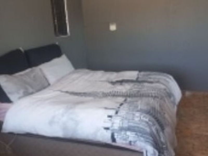 A bedroom featuring tiled flooring and dark-toned walls.