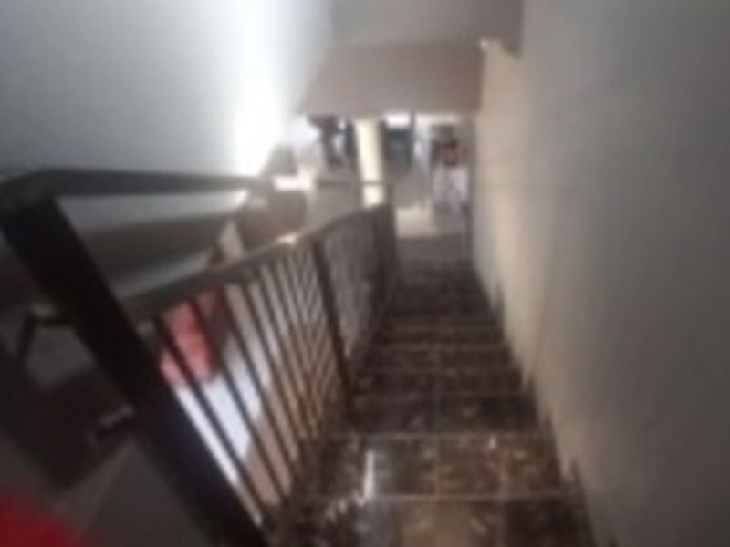 A view looking down a staircase featuring tiled steps and a metal balustrade.