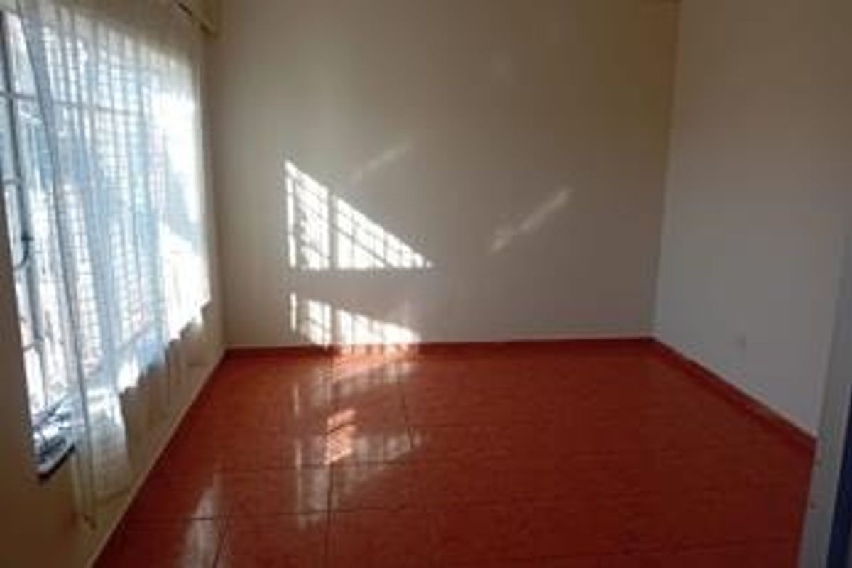 A vacant bedroom featuring tiled flooring and a window fitted with security bars, offering a clean and neutral space ready for personalization.
