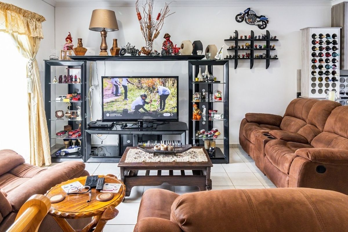 A comfortable living room featuring tiled flooring and a built-in wine storage unit, providing a functional space for relaxation and entertainment.