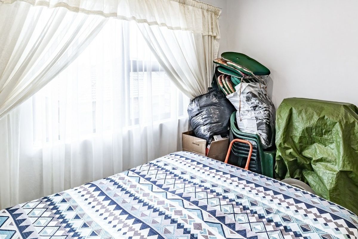 A bedroom featuring a window with installed curtain rails, providing natural light to the space.