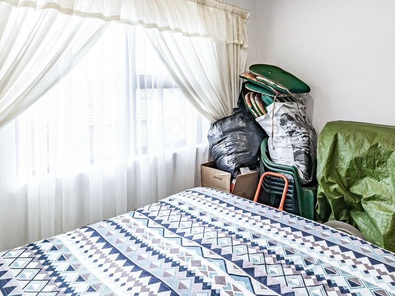 A bedroom featuring a window with installed curtain rails, providing natural light to the space.