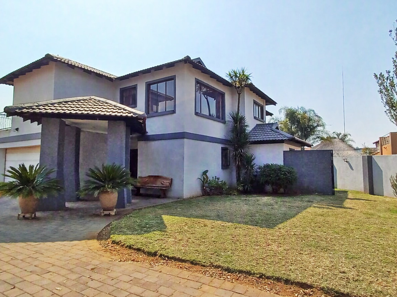 A well-maintained double-story residential property featuring a paved driveway, integrated garage, and a neat front garden with a covered entrance.