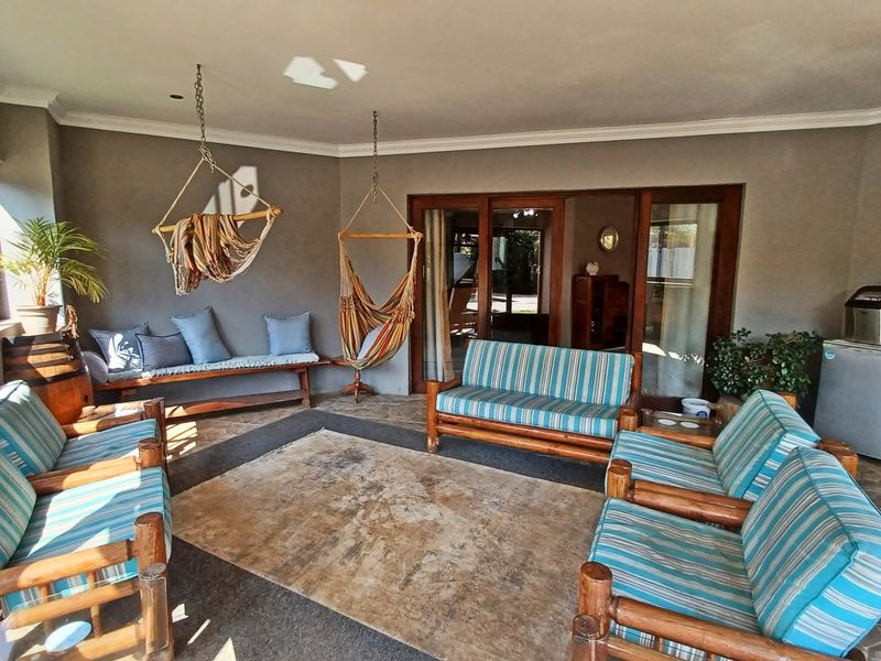 A covered patio area featuring stone flooring, recessed lighting, and large sliding glass doors providing access to the interior living space.