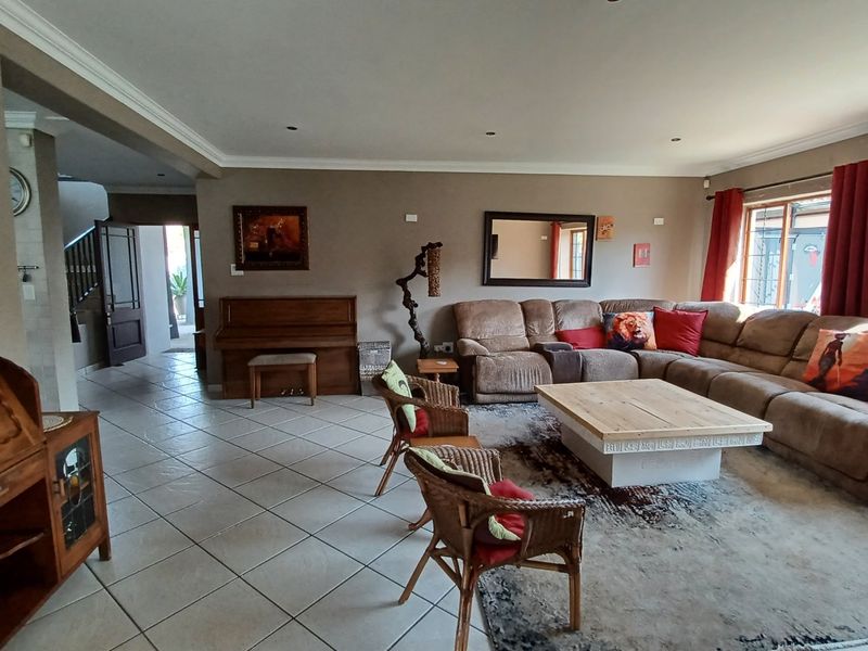 Spacious living room featuring neutral wall tones, tiled flooring, recessed lighting, and large sliding doors providing access to the exterior.