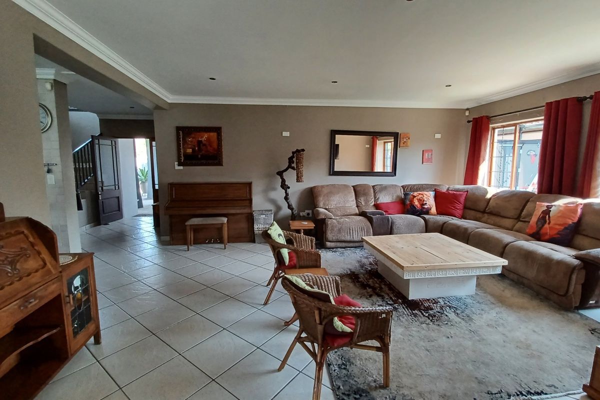 Spacious living room featuring neutral wall tones, tiled flooring, recessed lighting, and large sliding doors providing access to the exterior.
