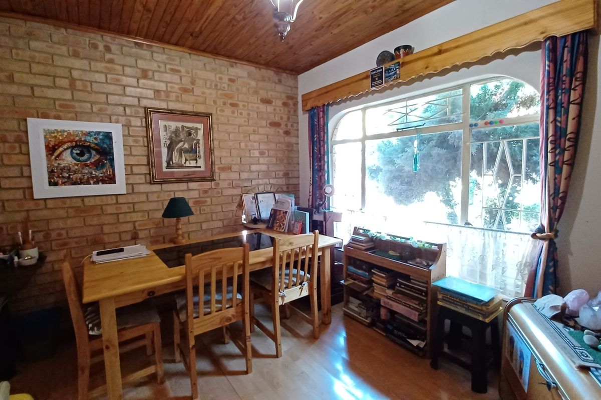 A living area featuring an exposed brick feature wall, timber ceiling, and a large arched window providing natural light.