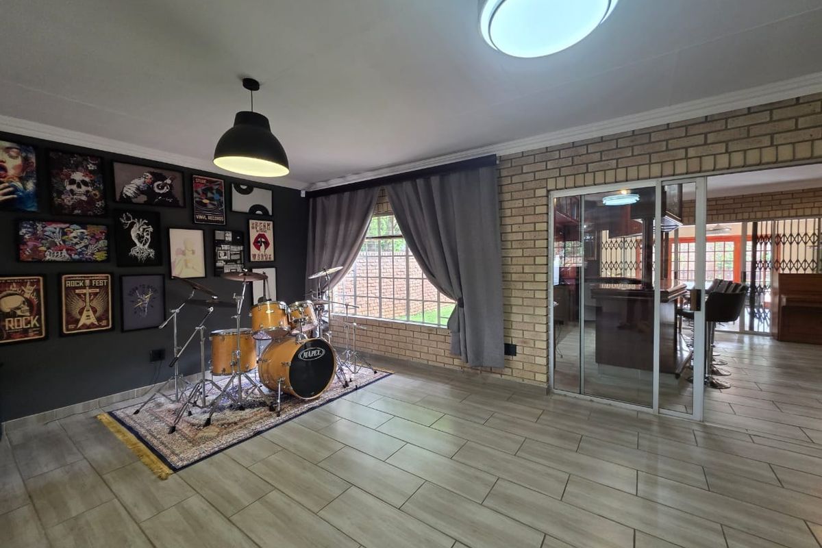 Spacious living area featuring exposed brick walls, tiled flooring, and a sliding glass door leading to an adjacent room.