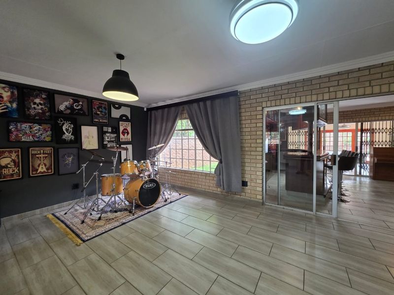 Spacious living area featuring exposed brick walls, tiled flooring, and a sliding glass door leading to an adjacent room.