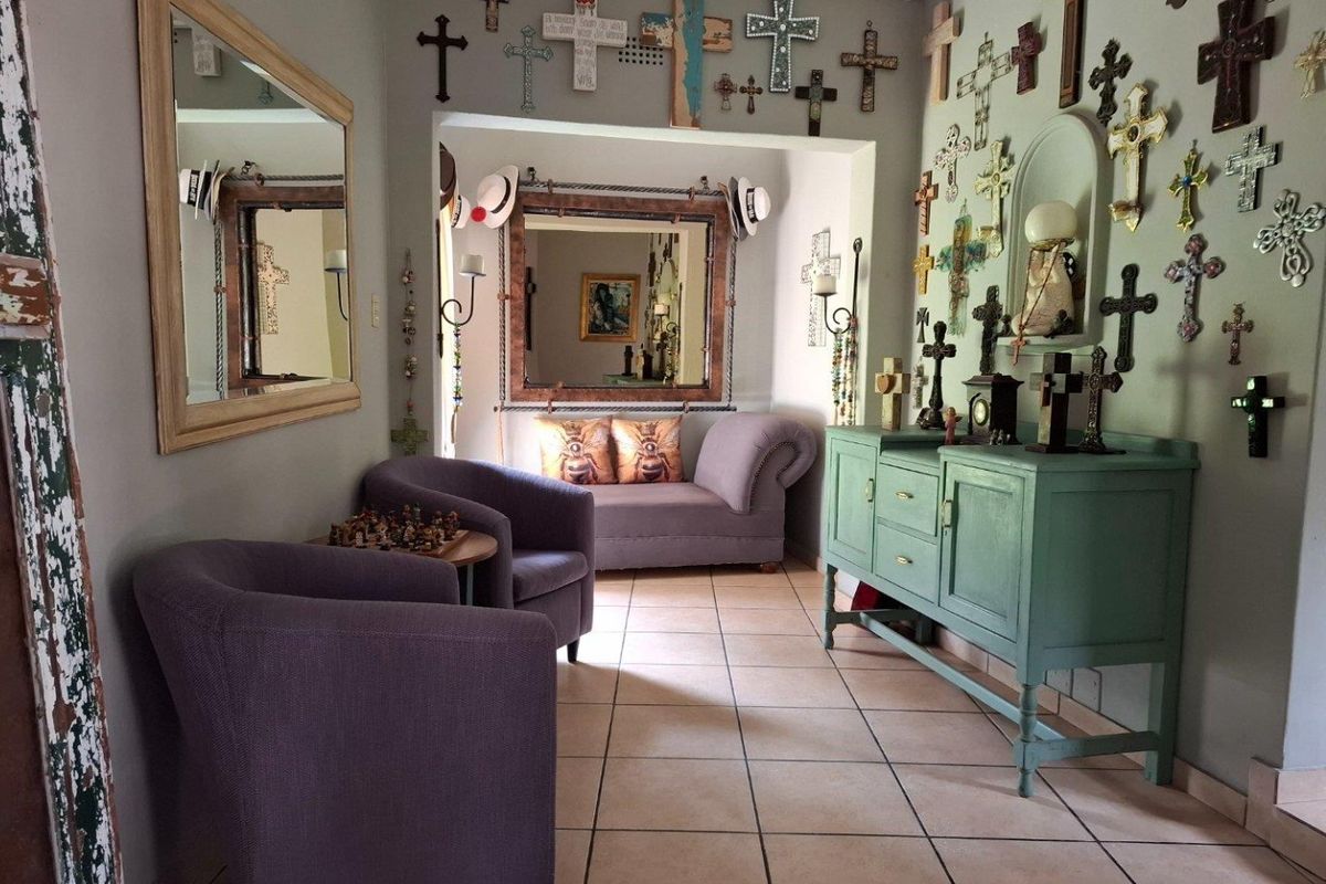 A living area featuring tiled flooring and an archway leading to an adjacent space, providing a neutral foundation for potential interior updates.