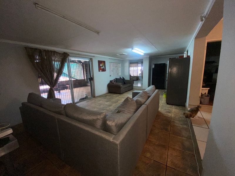 Spacious open-plan living area featuring tiled flooring and a sliding glass door providing access to the outdoor patio space.