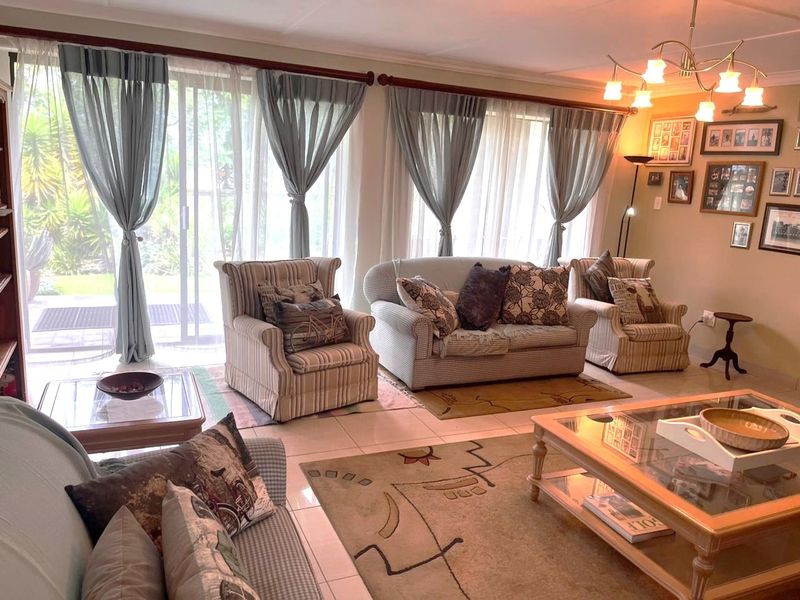 A comfortable living room featuring large sliding glass doors that provide natural light and direct access to the garden area.