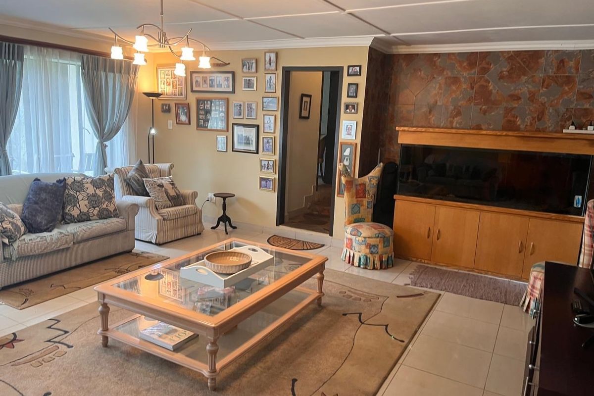 A spacious living room featuring tiled floors, a stone accent wall, and built-in cabinetry, offering a comfortable and functional living space.