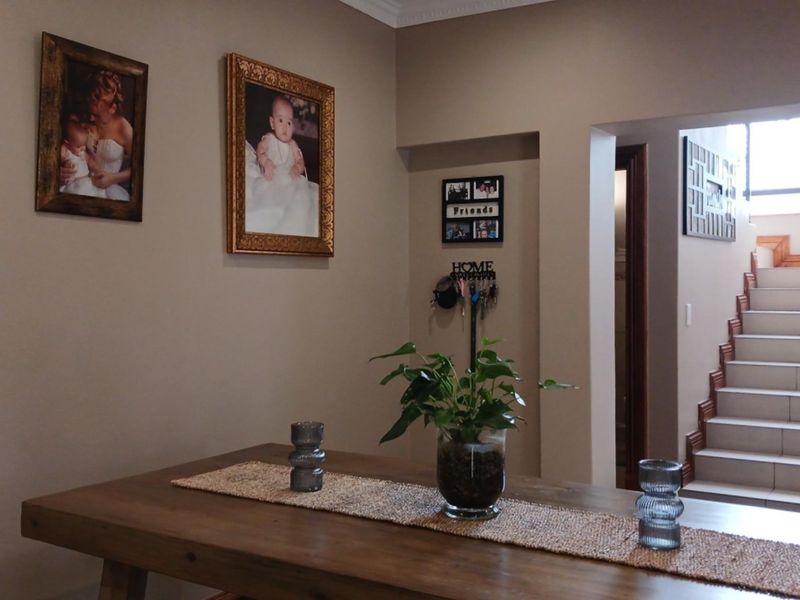 A dining area featuring neutral walls and a clear view of the internal staircase with tiled steps.