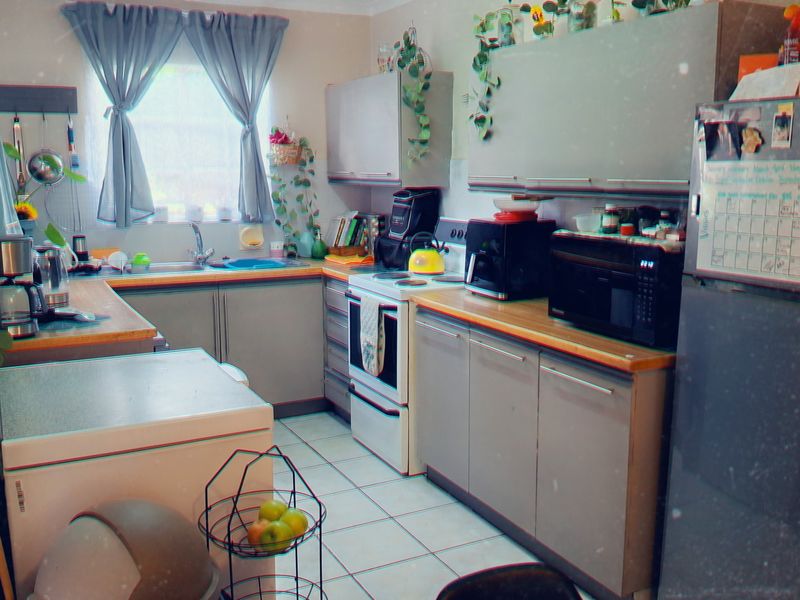 A functional kitchen featuring built-in cabinetry, laminate countertops, a stainless steel sink, and tiled flooring, providing a practical workspace for daily meal preparation.