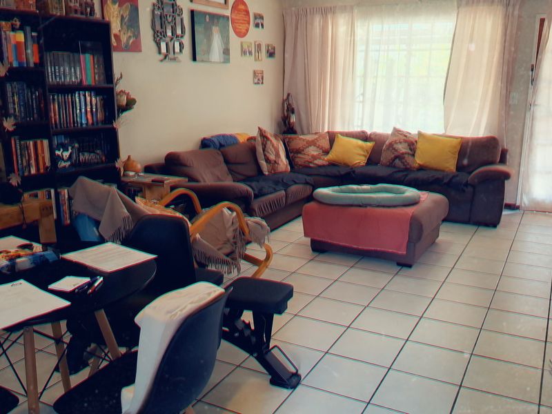 A spacious living room featuring tiled flooring and a sliding glass door providing natural light.