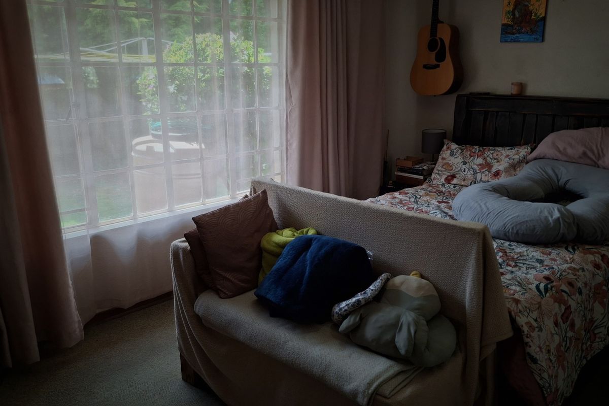 A bedroom featuring a large window that allows natural light, carpeted flooring, and a neutral layout suitable for personalization.