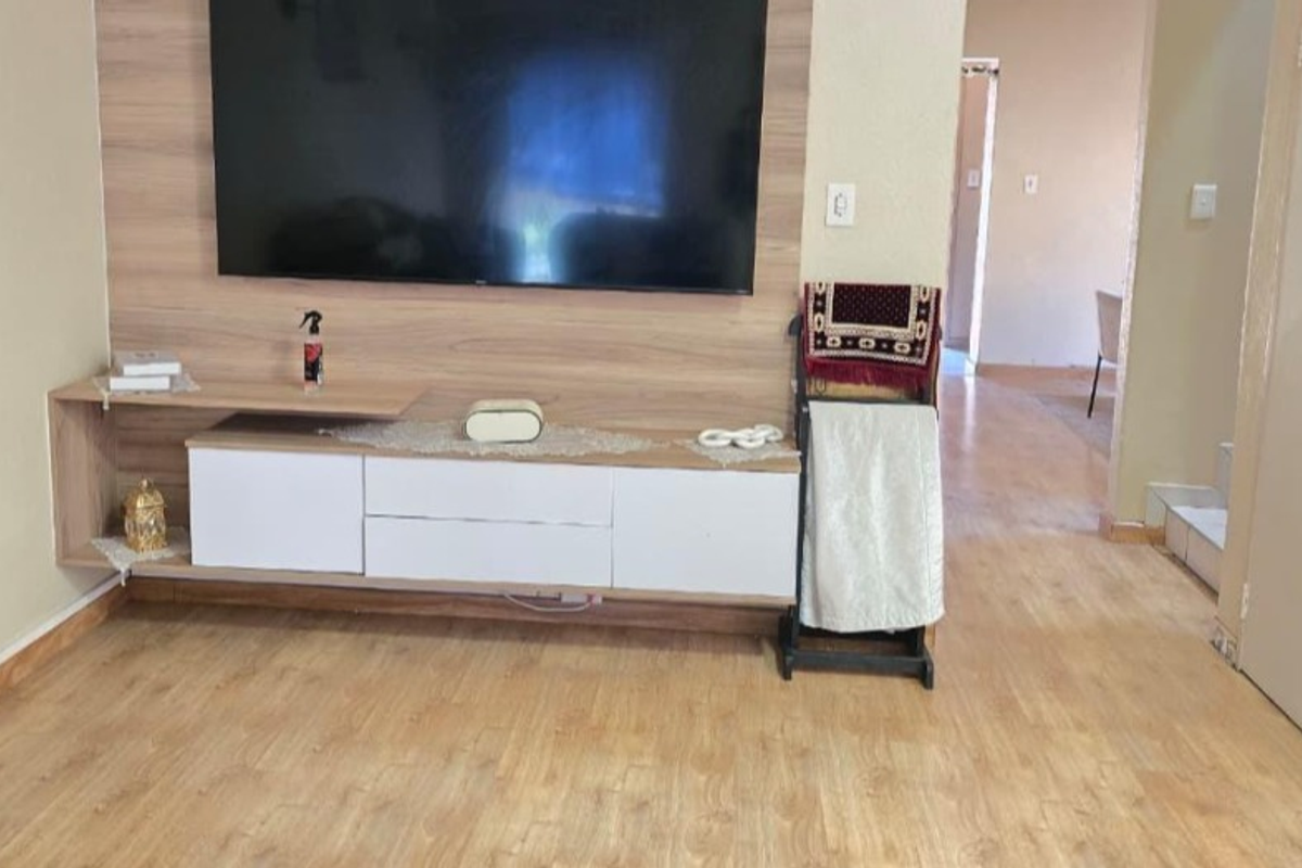 Living room featuring a modern built-in media console with wood-grain finish and light-toned laminate flooring throughout.
