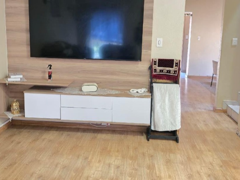 Living room featuring a modern built-in media console with wood-grain finish and light-toned laminate flooring throughout.