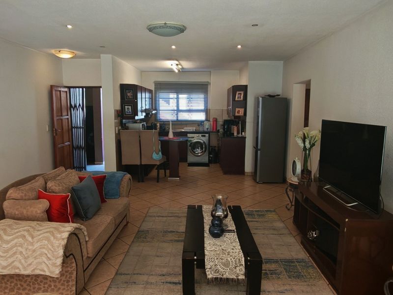 Open plan living and kitchen area featuring tiled flooring, recessed lighting, and functional built-in cabinetry.