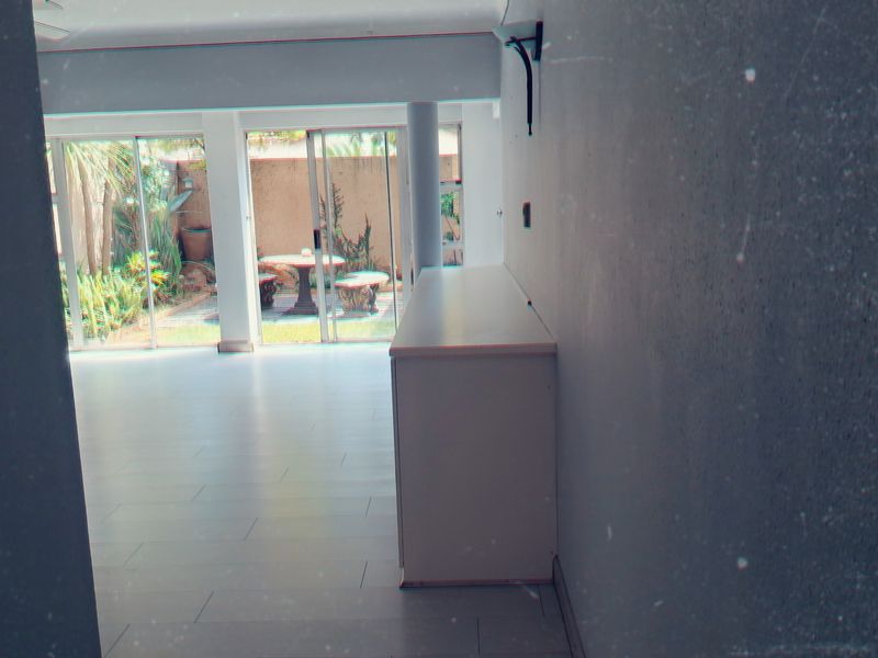 An empty living area featuring tiled flooring and sliding glass doors that provide direct access to the rear garden.