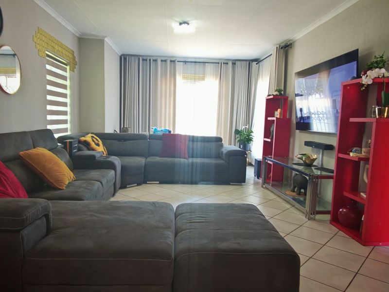 A spacious living room featuring tiled flooring and neutral wall tones, offering a comfortable and functional layout for relaxation.