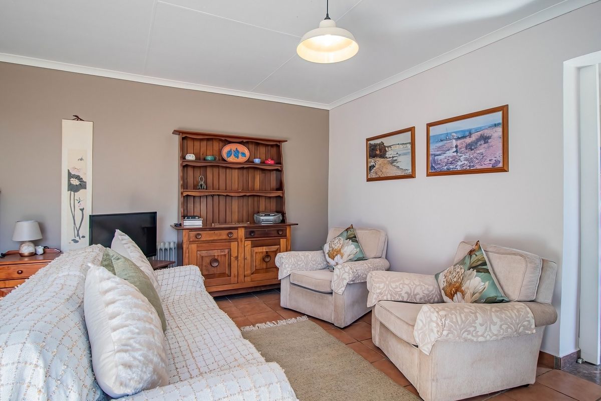 A comfortable living room featuring tiled flooring, coved ceilings, and neutral wall tones, providing a functional and well-maintained space.