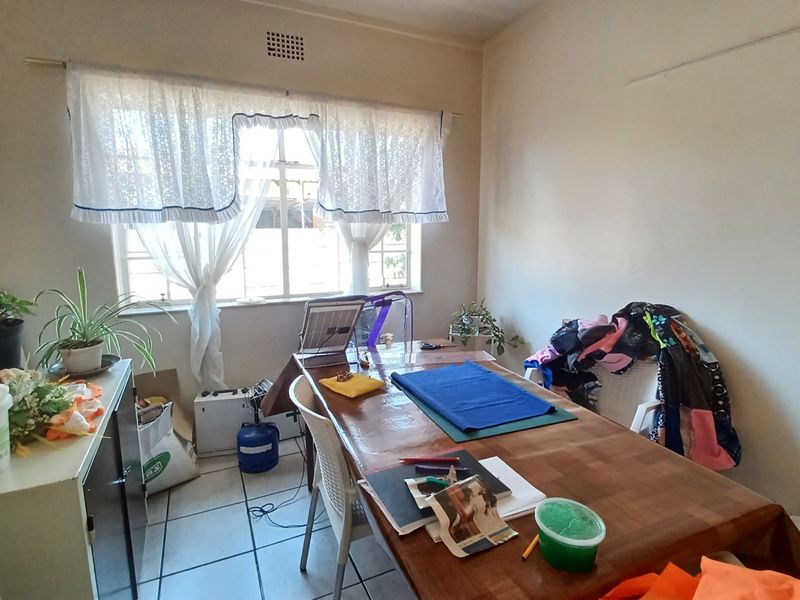 A functional dining room featuring tiled flooring and a large window with natural light, providing a versatile space for meals or activities.