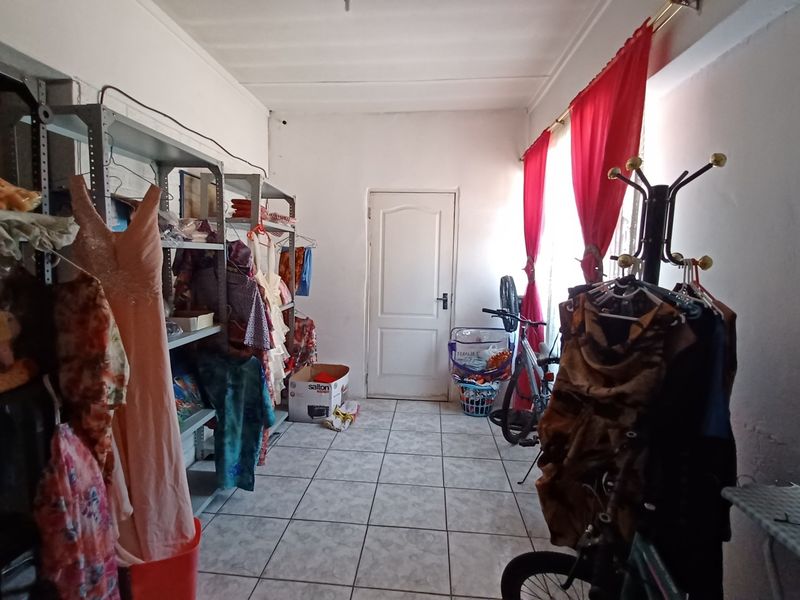 A functional utility space featuring tiled flooring and a central access door, currently utilized for storage and household organization.