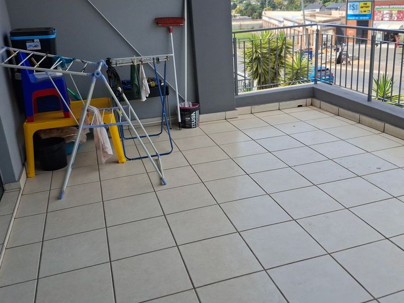 A tiled balcony area featuring a metal balustrade and sliding door access, providing an open outdoor space for the townhouse.