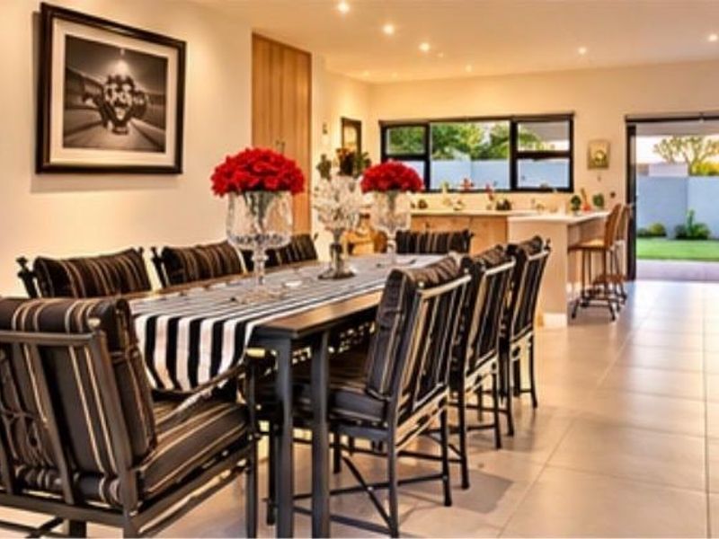 Spacious open-plan living and dining area featuring tiled floors, recessed lighting, and seamless access to the rear garden through bi-fold doors.