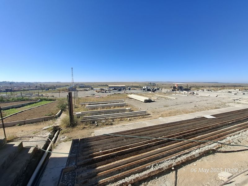 Expansive industrial yard area featuring concrete surfaces, perimeter fencing, and open space suitable for storage or operational use.