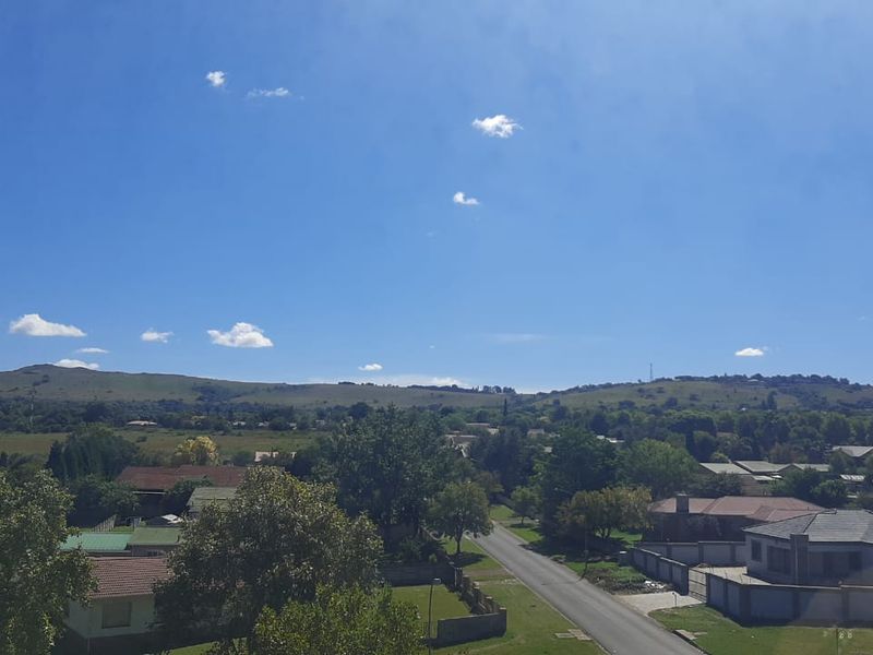 An elevated outdoor view overlooking a suburban residential area with surrounding hills and open landscape.