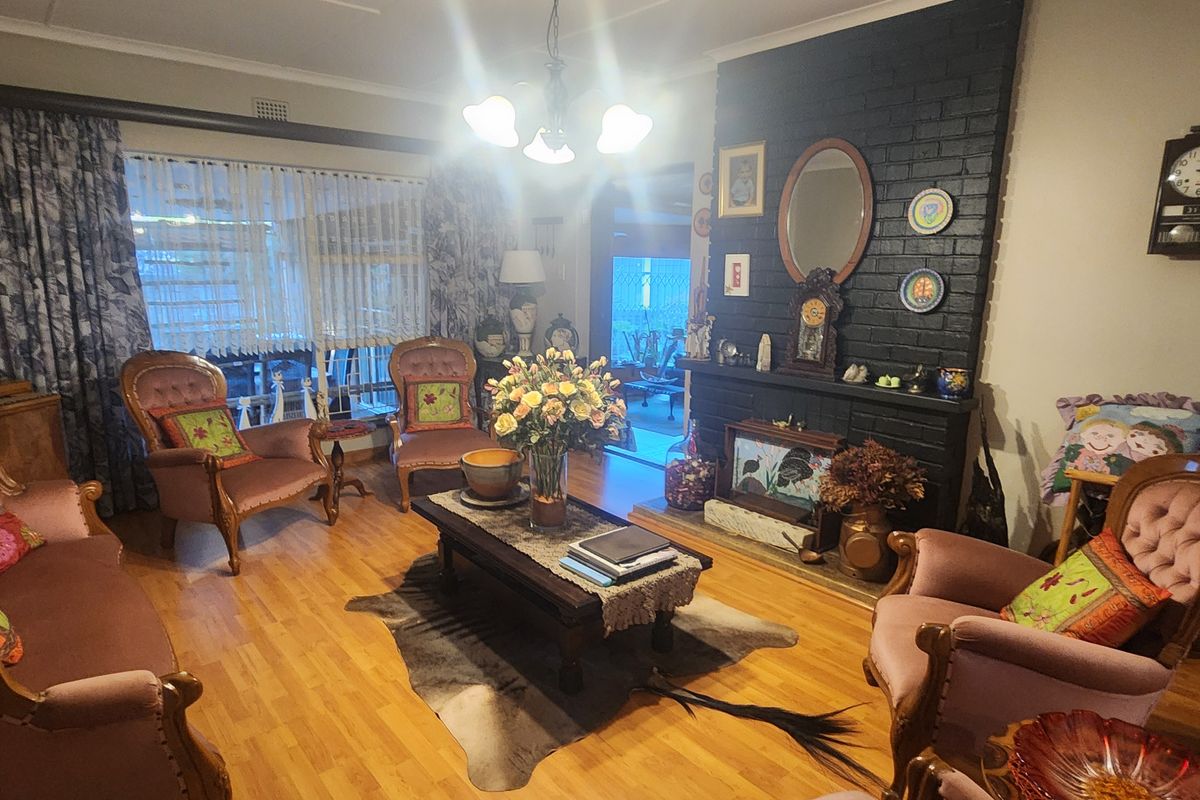 A cozy living room featuring a prominent black brick fireplace and laminate flooring, offering a traditional and inviting atmosphere.