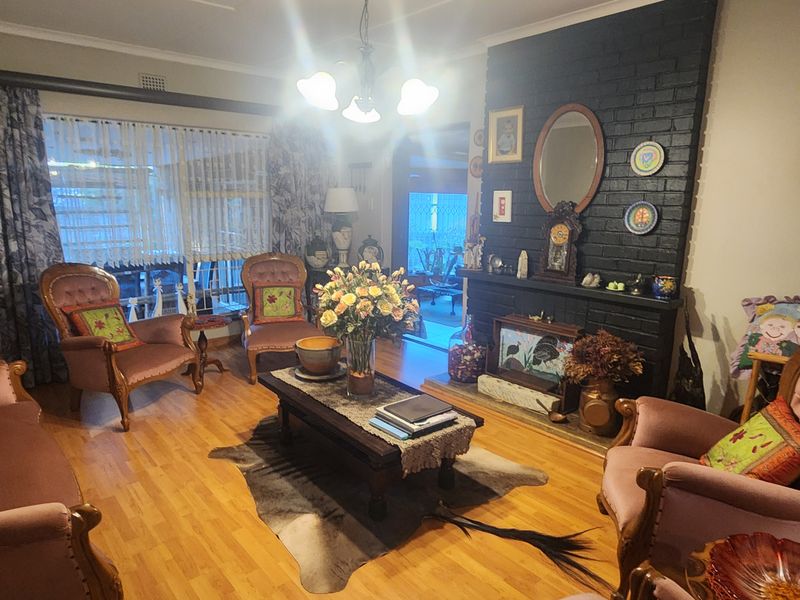 A cozy living room featuring a prominent black brick fireplace and laminate flooring, offering a traditional and inviting atmosphere.