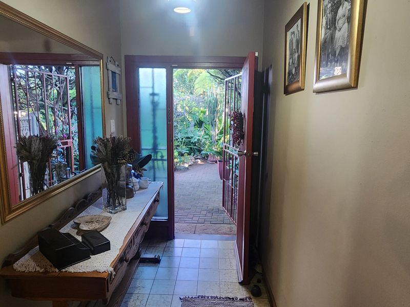 Entrance hall featuring tiled flooring and a glass panel door leading to an outdoor garden area.