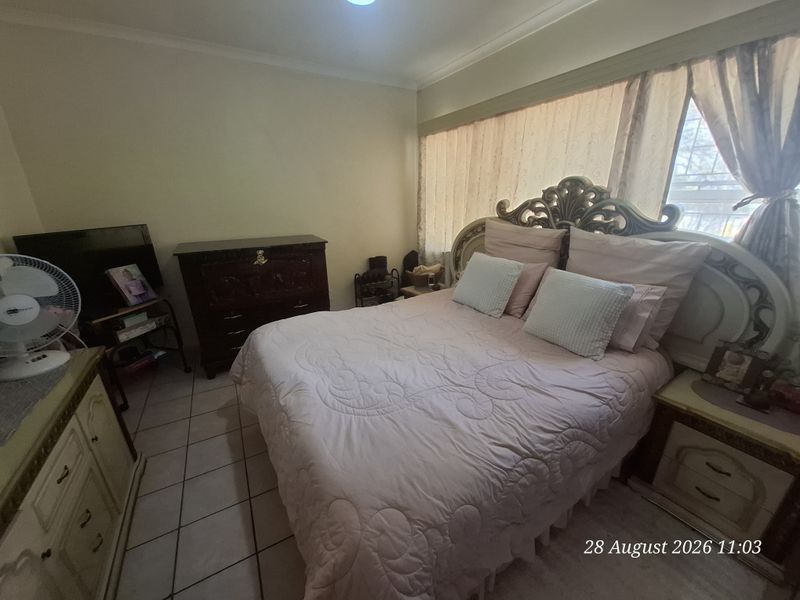 A bedroom featuring tiled flooring and coved cornicing, offering a functional space ready for potential cosmetic updates.