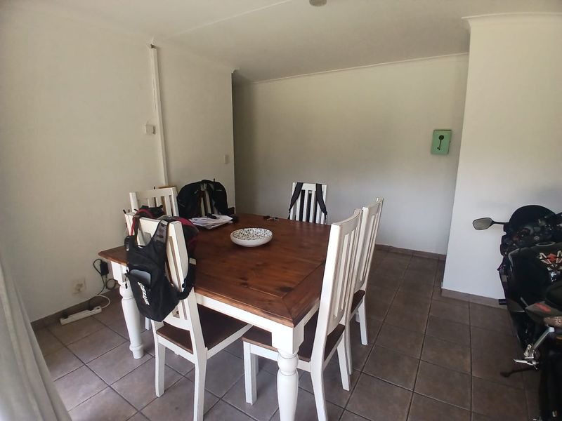A dining area featuring ceramic floor tiles and coved ceilings, providing a functional space for meals.