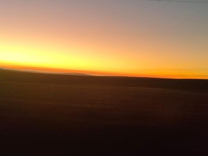 A scenic view of the horizon at sunset over the vacant residential land.